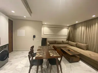 a living room with a couch and a table and chairs at Hilbert Princesses - Furnished apartments in Casablanca