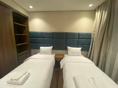 a room with two beds and a blue head board at Hilbert Princesses - Furnished apartments in Casablanca