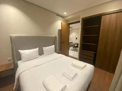a bedroom with a large white bed with two towels on it at Hilbert Princesses - Furnished apartments in Casablanca