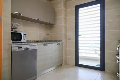 a kitchen with a window and a sink and a microwave at Magnificient Appartment in Prestigia in Rabat