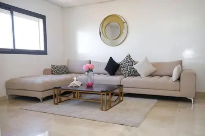 a living room with a couch and a table at Magnificient Appartment in Prestigia in Rabat