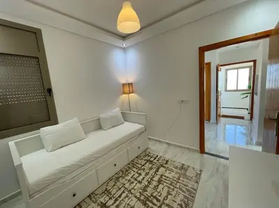a white couch in a living room with a window at A3 Luxe and Cosy Apartement, 7 min du Stade Moulay Abdellah in Temara
