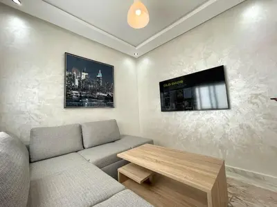 a living room with a couch and a table at A3 Luxe and Cosy Apartement, 7 min du Stade Moulay Abdellah in Temara