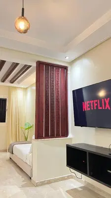 a bedroom with a netflix sign on the wall at SUITOUISS - Agdal 1 - Appartement à 2 minutes de la gare de train TGV Rabat in Rabat