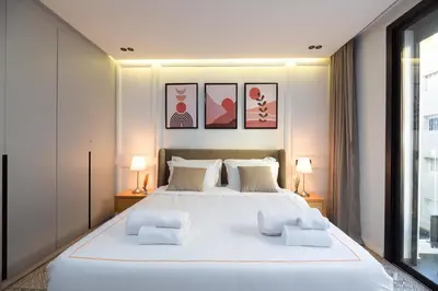 a bedroom with a large white bed with two lamps at Cosy & So Stylish Appartement Au coeur de Casablanca Bd 2 Mars Derrière Kfc 2 Min à Pieds vers Mcdo in Casablanca