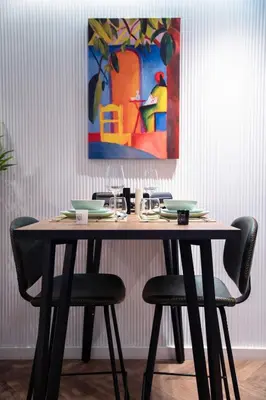 a dining table with chairs and a painting on the wall at Cosy & So Stylish Appartement Au coeur de Casablanca Bd 2 Mars Derrière Kfc 2 Min à Pieds vers Mcdo in Casablanca