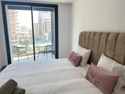 a bedroom with a large bed with a large window at Appartement CFC - Aeria mall in Casablanca