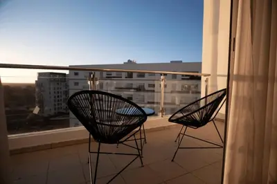two chairs on a balcony with a view of a building at Beautifully Designed 3BR Apartment+ Panoramic View in Rabat