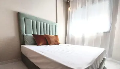 a bedroom with a bed with a blue headboard and a window at Appart relax aéroport 5 min in Nouaceur