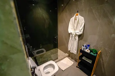 a bathroom with a toilet and a robe on a wall at ROYAL ANFA PARK SUITE-BY AYLA STAY in Casablanca