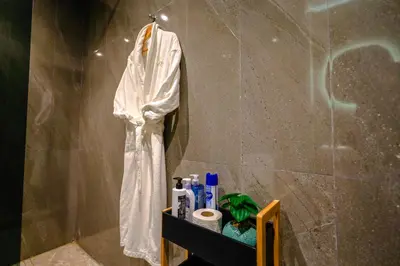 a bathroom with a white robe hanging on a wall at ROYAL ANFA PARK SUITE-BY AYLA STAY in Casablanca