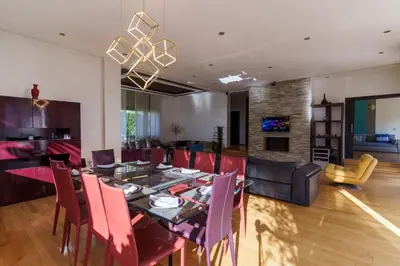 a dining room and living room with a table and chairs at Luxury villa Bouskoura Pearl in Casablanca