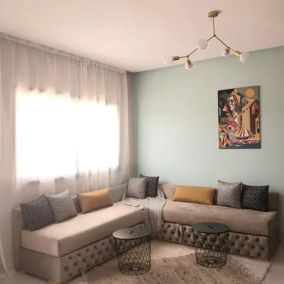 a living room with a couch and a window at Airport mohamed 5 break apartments in Derroua