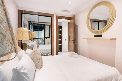 a bedroom with a white bed and a mirror at TTHOLIDAYS Cosy Apartment Casablanca City Center in Casablanca