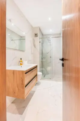 a white bathroom with a sink and a shower at TTHOLIDAYS Cosy Apartment Casablanca City Center in Casablanca