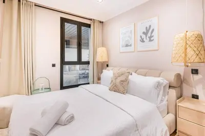 a bedroom with a white bed and a window at TTHOLIDAYS Cosy Apartment Casablanca City Center in Casablanca