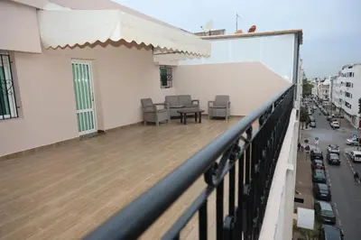 a balcony with chairs and a table on a building at Agdal 1 in Rabat
