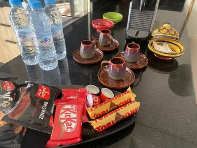 a table with cups and plates of food and water at Maarif , Cosy 2 Chambres, Parking wifi Netflix Gratuit in Casablanca