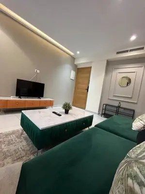 a living room with two beds and a flat screen tv at Charming apartment at Maarif in Casablanca