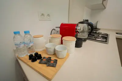 a kitchen counter with water bottles and cups on a cutting board at studio Maarif à 3min à pied du stade med V in Casablanca