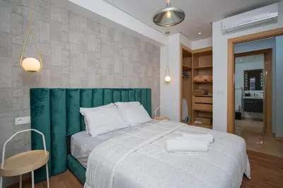 a bedroom with a large bed with a green headboard at studio Maarif à 3min à pied du stade med V in Casablanca