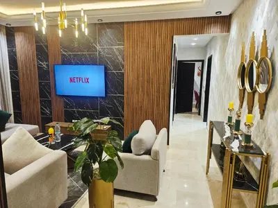 a living room with a tv on a wall at modern apartment opposite to HASSAN2 MOSQUE & FAIR international casablanca , near downtwn, with side SEA view with sports machines with free underground GARAGE prohibited for unmarried couples of Arab original apartment too QUIET in Casablanca