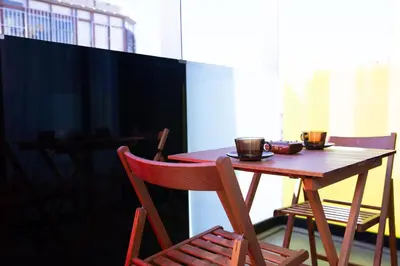 a wooden table and chairs with two cups on it at Appartement neuf 2 chambres avec salle de sport in Casablanca