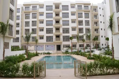 an apartment building with a swimming pool in front of it at Luxury apartment fully furnished in Casablanca