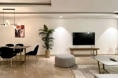 a living room with a table and a flat screen tv at Business Travelers and Families - 3 Bedrooms in Casablanca