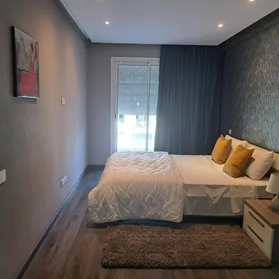 a bedroom with a large bed and a window at Studio ALMASSIRA in Casablanca