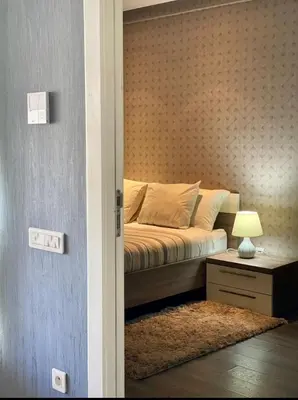 a bedroom with a bed and a table with a lamp at Studio ALMASSIRA in Casablanca