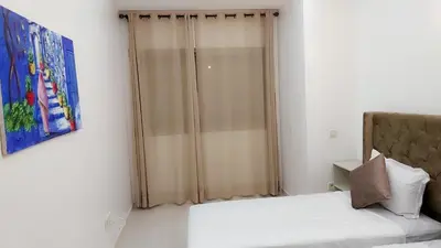 a bedroom with a bed and a glass shower at Appartement Perla - Costa Bouznika in Bouznika