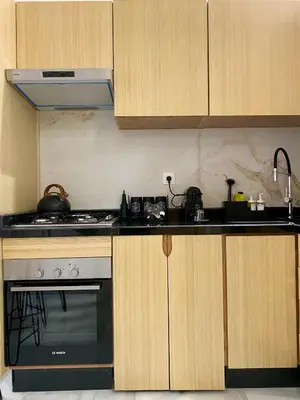 a kitchen with wooden cabinets and a stove top oven at Élégance en 40 mètres Nouaceur in Nouaceur