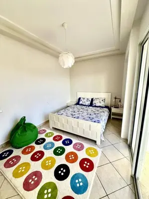a bedroom with a bed and a colorful rug at Oasis de Sérénité en Bord de Mer in Casablanca