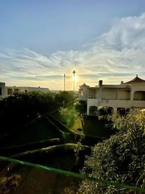 a view of a building with the sun setting in the background at Oasis de Sérénité en Bord de Mer in Casablanca