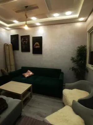 a living room with a green couch and a table at Charmant appartement 15 minutes de la plage in Mohammedia