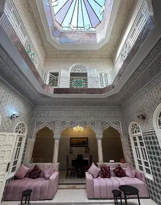 a living room with pink couches and a stained glass window at Riad Blue Garden in Rabat
