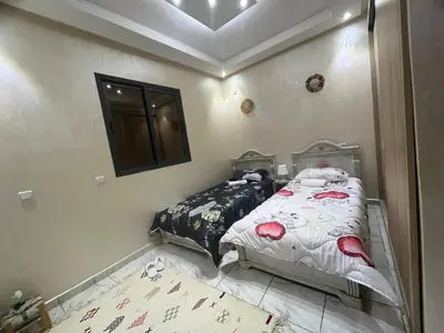 a bedroom with two beds and a mirror on the wall at Dar MAKTOUBE in Mohammedia