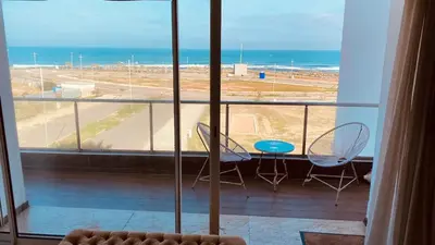 a balcony with a table and chairs and the ocean at Bel appartement pieds sur mer in Casablanca