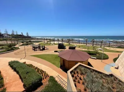 a view of a park with the ocean in the background at Bel appartement pieds sur mer in Casablanca