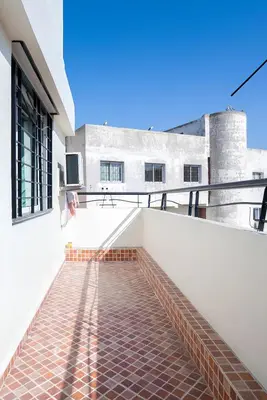 a balcony with a brick floor and a building at Spacieux appartement 80 m² - Centre de Casablanca in Casablanca