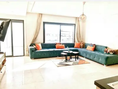 a living room with a green couch and a table at Cosy 80 m2 with 2 balcony 5min Hassan 2 in Casablanca