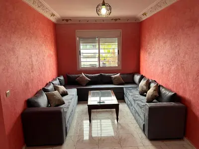 a living room with a couch and a table at Appartement chic in Tit Mellil