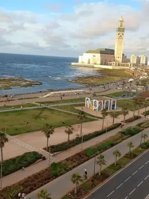 a city with a clock tower next to the ocean at Appartement moderne vue sur mer in Casablanca