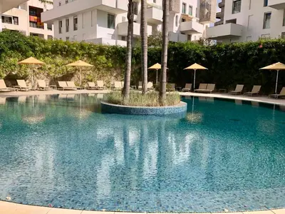 a large swimming pool with umbrellas in a building at Anfa Finance City CFC! Magnifique Apt Tours Végétales, grande terrasse, piscine, parking in Casablanca