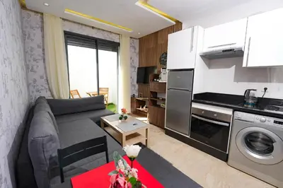 a living room with a couch and a kitchen at Studio anfa plaza in Casablanca