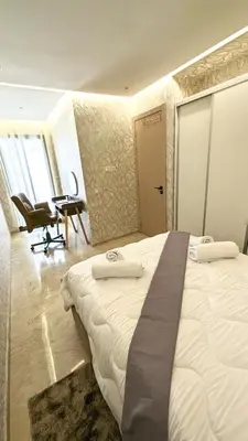 a bedroom with a large white bed and a desk at Studio anfa plaza in Casablanca