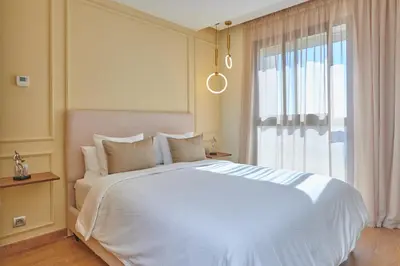 a bedroom with a large white bed and a window at YourPlace Rabat - Royal Residence in Rabat