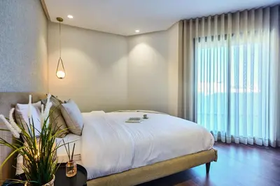 a bedroom with a bed and a large window at Sleek and Modern 2-Bed Unit in Downtown Casa in Casablanca