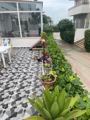 a garden with plants and flowers on a patio at Marbella Beach Almansouria in Mansouria
